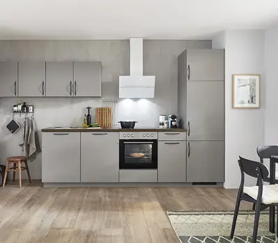 Moderne Küchenzeile in elegantem Grau mit Holzfußboden und weißen Wänden, ausgestattet mit Backofen, Dunstabzugshaube und funktionaler Arbeitsfläche, ideal für zeitloses urbanes Wohnen.